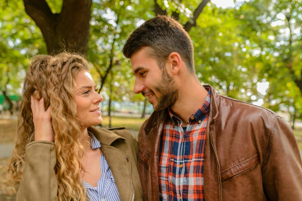 Man leaning towards a a woman in a park 