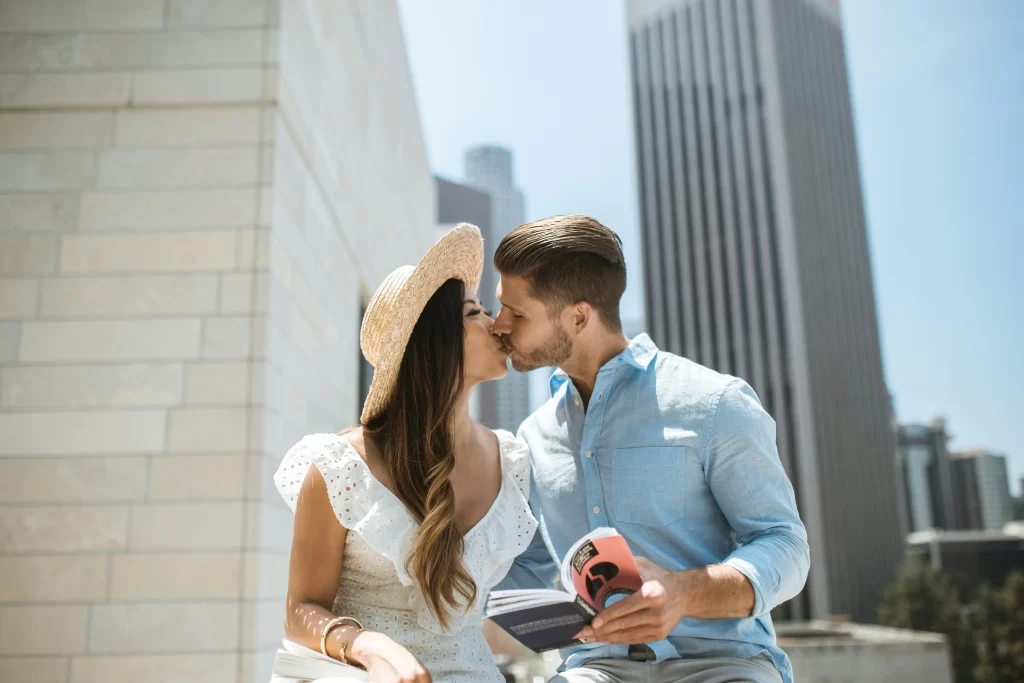 Man and woman kissing outside daytime city