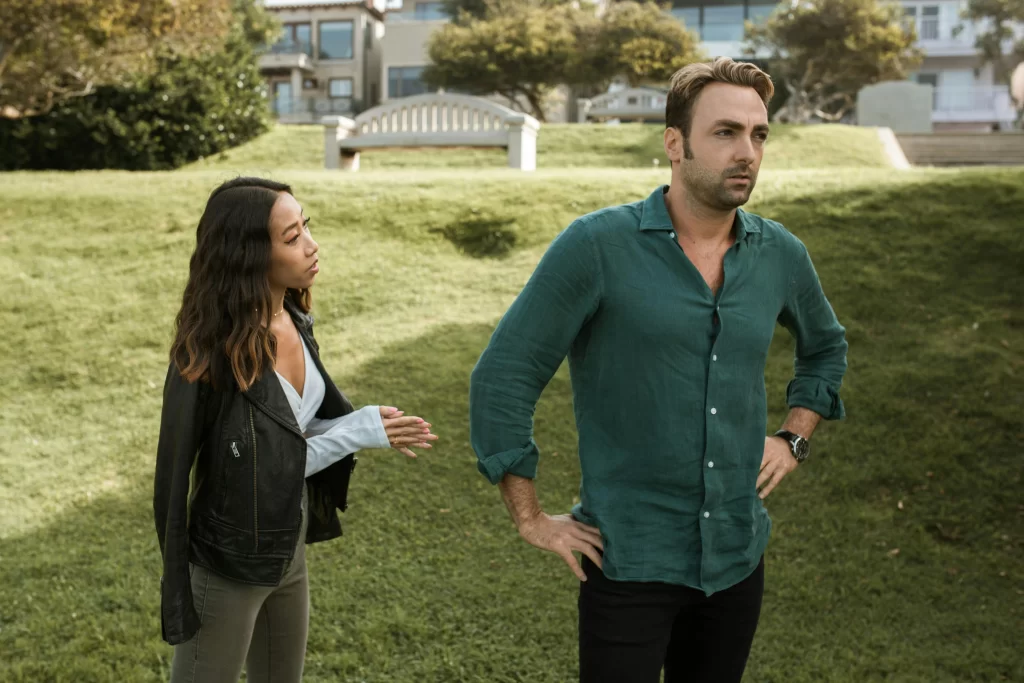 A man ignoring a woman in a park who is pleading with him