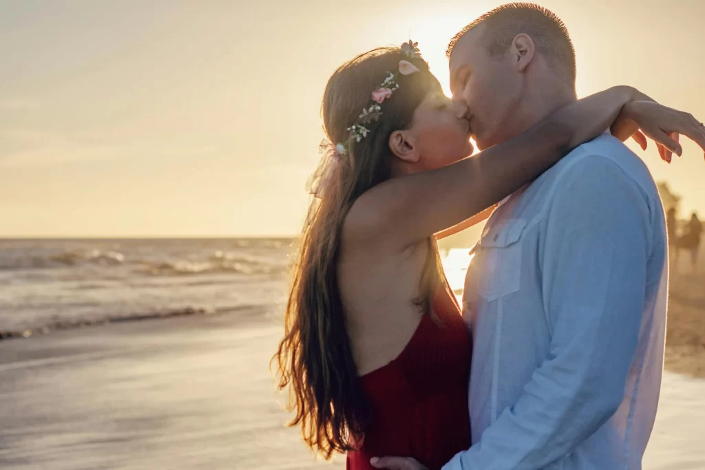 Man and woman kissing at the beach at sunset