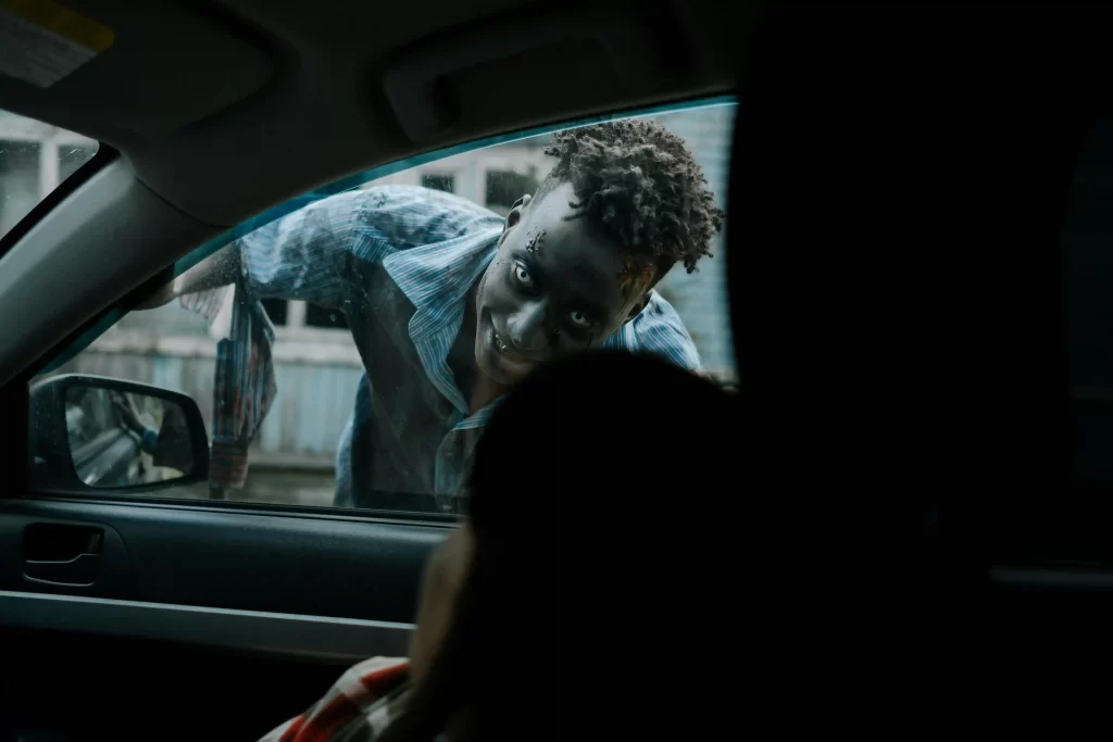 Creepy guy looking in the window of a car at a scared woman