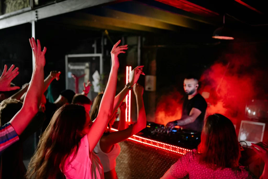 A dj playing a set for fans in a dark club